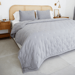
                    
                      Cubrecama gris con patrón punteado en cama de madera y rattan-gris
                    
                  