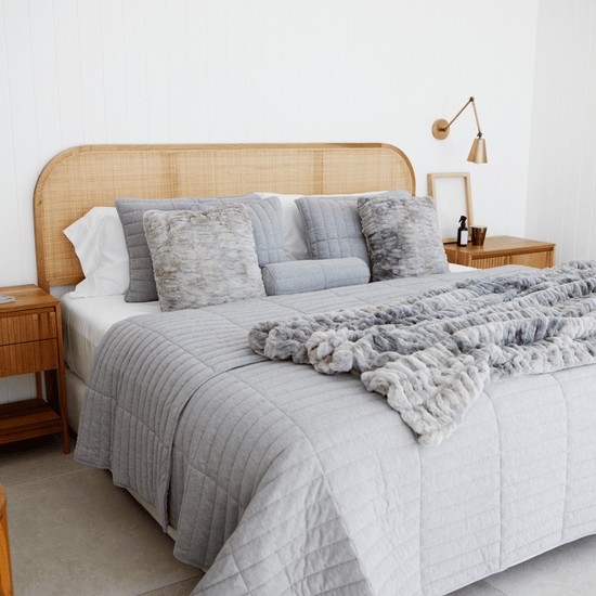 Cubrecama gris claro Vigo en cama con cabecera de ratán y almohadas-gris claro