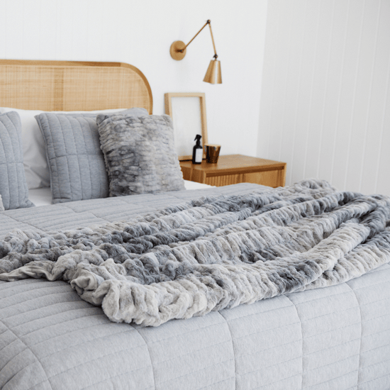 Cubrecama Vigo gris claro sobre cama con almohadas y mesita de noche-gris claro