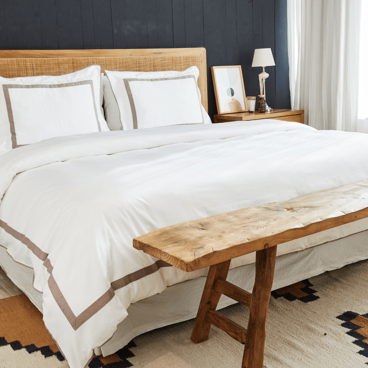 Almohada decorativa blanca con aplique beige en cama elegante-beige