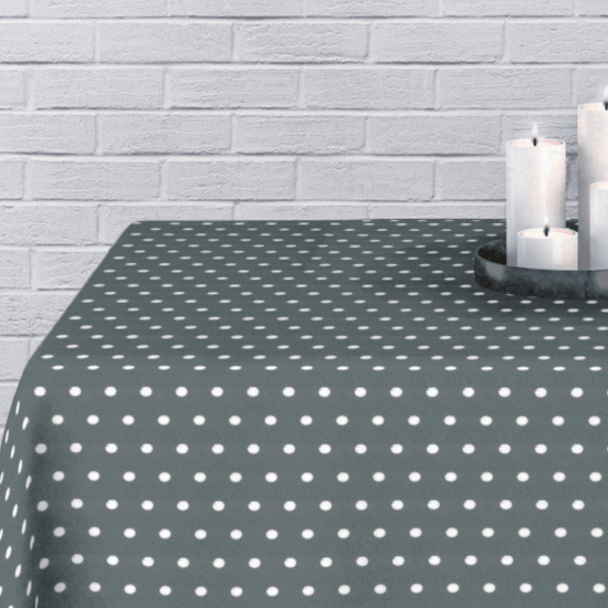 Mantel gris con lunares blancos sobre pared blanca con velas-gris