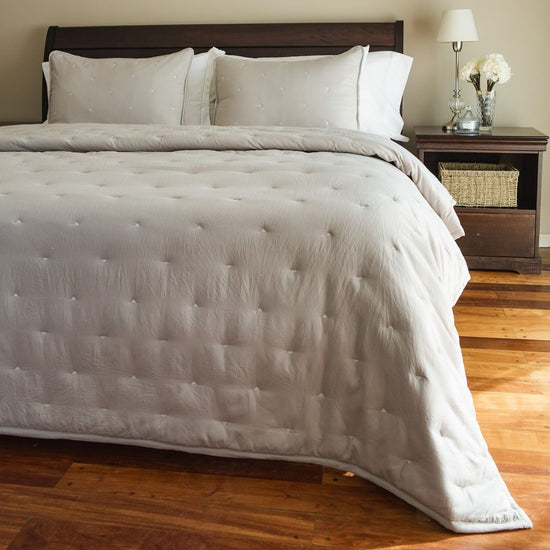 Cama con edredón blanco acolchado y almohadas decorativas-natural