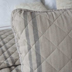 Funda de almohada beige con rayas grises y costuras decorativas-