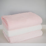 
                    
                      Tres frazadas polar apiladas en tonos rosa y blanco suave-rosa
                    
                  