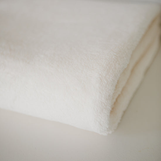 Detalle de textura suave de frazada polar blanca natural para niños-natural