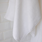 
                    
                      Toallón blanco colgado mostrando textura suave y absorbente-blanco
                    
                  