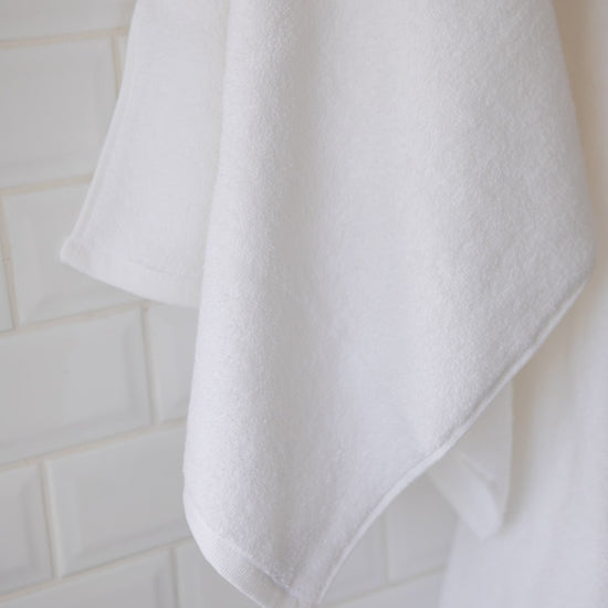 Toallón blanco colgado mostrando textura suave y absorbente-blanco