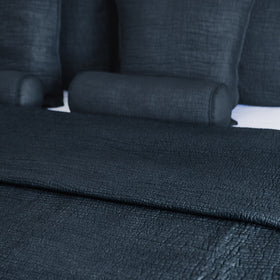 Cubrecama azul oscuro con cojines decorativos en cama-azul