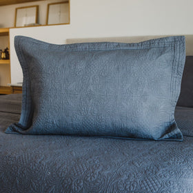 Funda de almohada Amalfi gris claro con patrón quilted sobre cama-gris-claro