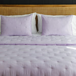 
                    
                      Cubrecama acolchado lila con almohadas a juego en cama moderna-lila
                    
                  