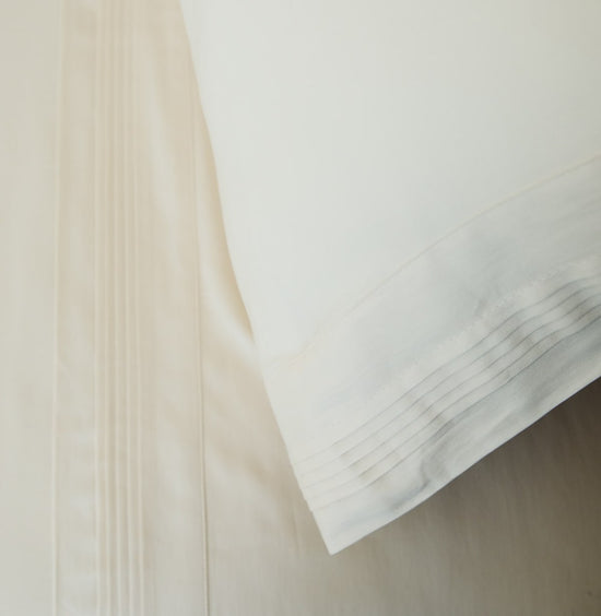 Detalle de sábanas plisadas blancas con textura de hilos naturales-natural