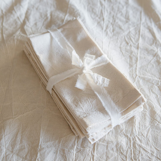 Pack de cuatro servilletas blancas de tela lisas atadas con cinta-liso