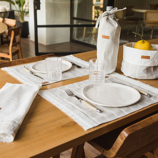 Mesa de madera con servicio de mesa blanco y lino a rayas-rayado
