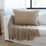 
                    
                      Funda de almohada Ginger 3 beige en sillón blanco junto ventana-
                    
                  