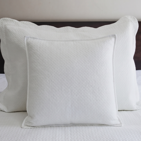 Almohada blanca con forma recta sobre cama con cabecero oscuro-blanco