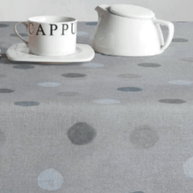 Mantel gris con puntos y taza de café blanca con jarra-gris