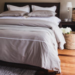 
                    
                      Cama con funda edredón gris, almohadas blancas y decoración elegante-gris
                    
                  