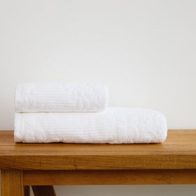 Set de toallas blancas enrolladas sobre mesa de madera-blanco