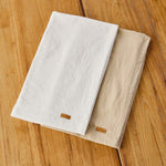 
                    
                      Dos caminos de mesa lisos en blanco y beige sobre madera-natural
                    
                  