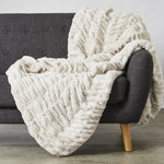 
                    
                      Manta blanca texturizada draped sobre silla gris con patas de madera-
                    
                  
