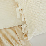 
                    
                      Detalle de funda almohada beige con cinta blanca decorativa-natural
                    
                  