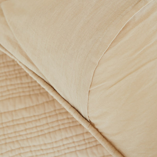 Funda de almohón beige con textura suave y pliegues naturales-beige
