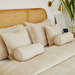 
                    
                      Cubrecama beige con almohadas decorativas y cojines cilíndricos en cama-beige
                    
                  