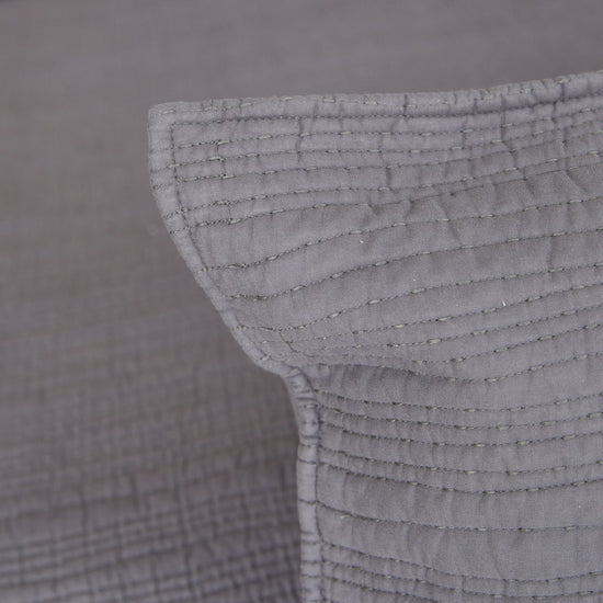 Detalle de funda de almohada gris con costuras horizontales decorativas-gris