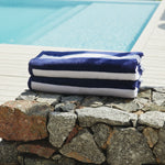 
                    
                      Toallas de playa a rayas azul y blanco sobre muro de piedra junto a piscina-azul
                    
                  
