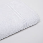 
                    
                      Toalla blanca enrollada mostrando textura suave y líneas decorativas-blanco
                    
                  