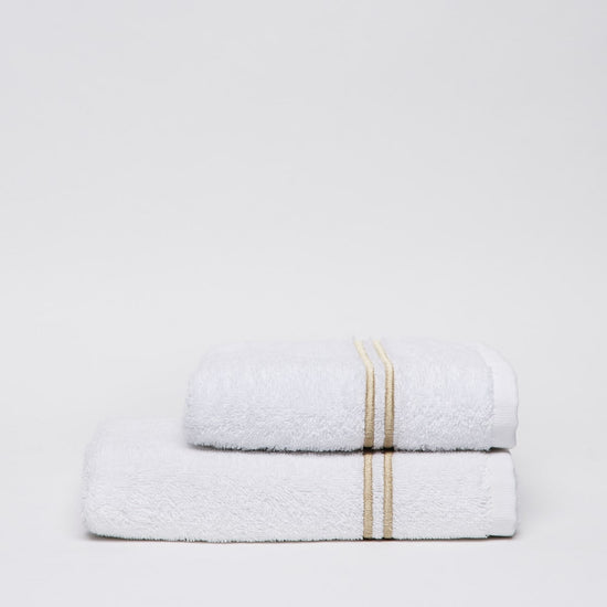 Dos toallas blancas apiladas con rayas beige decorativas-beige