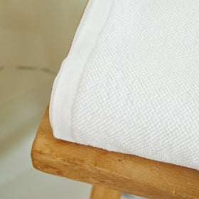 Toalla de baño blanca premium doblada sobre madera-blanco