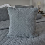 
                    
                      Funda de almohada gris acolchada en cama con edredón coordinado-
                    
                  
