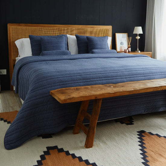 Cubrecama azul Pamplona sobre cama con cabecero de ratán-azul