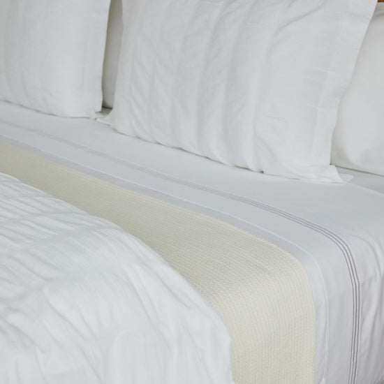 Manta blanca sobre cama con almohadas blancas-blanco