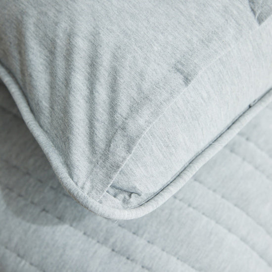 Funda de almohada gris clara con detalle de costura y textura suave-gris