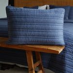 
                    
                      Funda almohada azul acolchada sobre banco madera junto sofá-azul
                    
                  