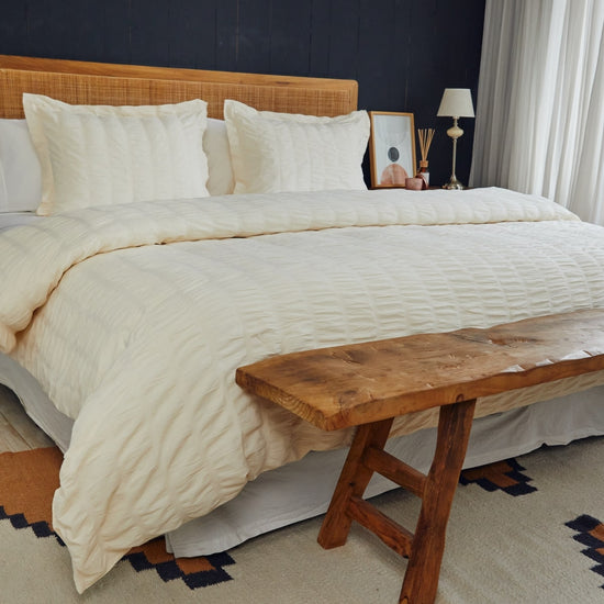 Cama con funda edredón beige y almohadas blancas en dormitorio moderno-natural