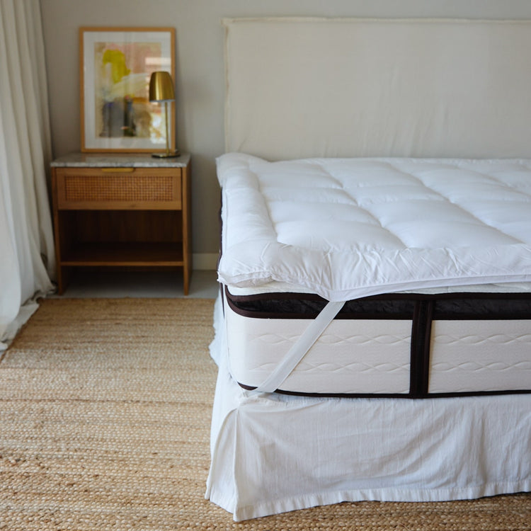 Cama con colchón y protector acolchado blanco en habitación moderna-blanco