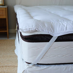 
                    
                      Almohada de pluma blanca sobre colchón con protector en habitación-
                    
                  