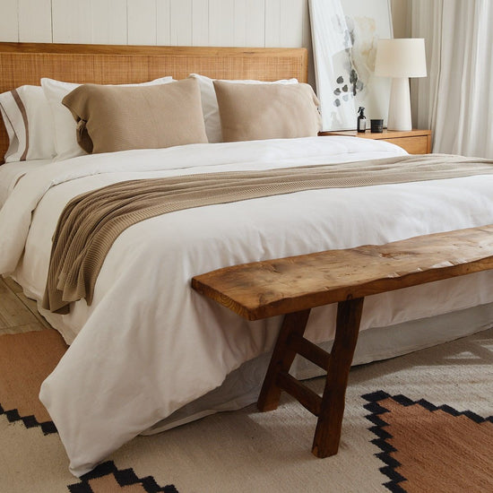 Manta Ginger 5 beige sobre cama blanca en dormitorio elegante-