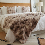 
                    
                      Manta de piel sintética con textura bubble print en tonos beige sobre cama-
                    
                  