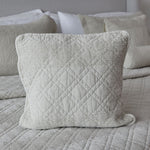 
                    
                      Funda de almohada acolchada beige con patrón de diamantes en cama-
                    
                  