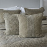 
                    
                      Dos fundas de almohada beige acolchadas sobre cama gris-
                    
                  