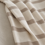 
                    
                      manta tejida con diseño a rayas sobre sillón-beige
                    
                  