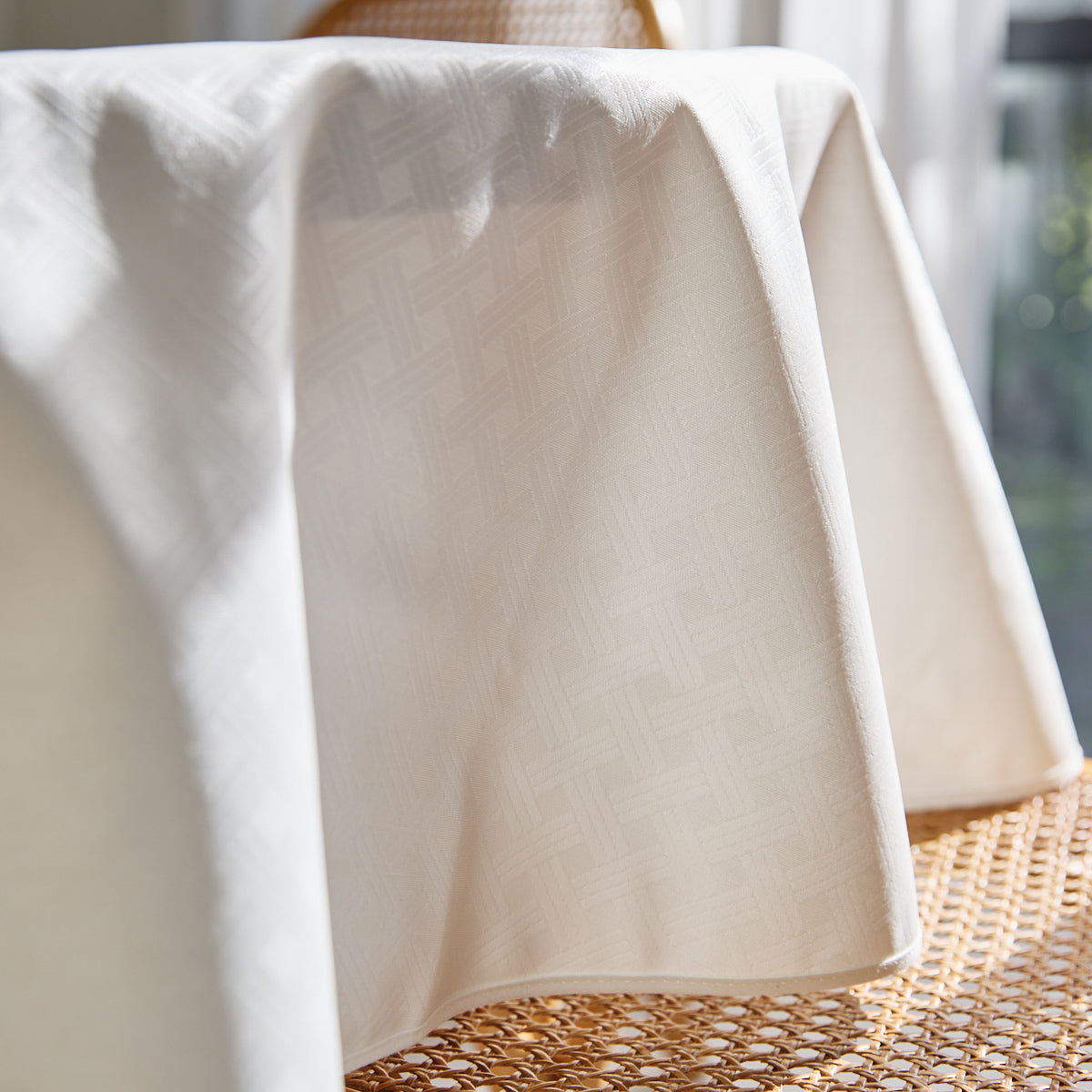 Mantel blanco doblado sobre superficie tejida de fibra natural-blanco