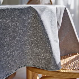 Mantel gris Goya doblado sobre mesa de madera clara-gris