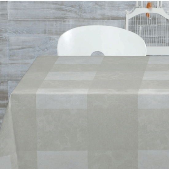 Mantel cuadrado beige sobre mesa con silla blanca de fondo-