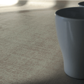 Mantel Murillo beige con taza blanca sobre superficie clara-beige