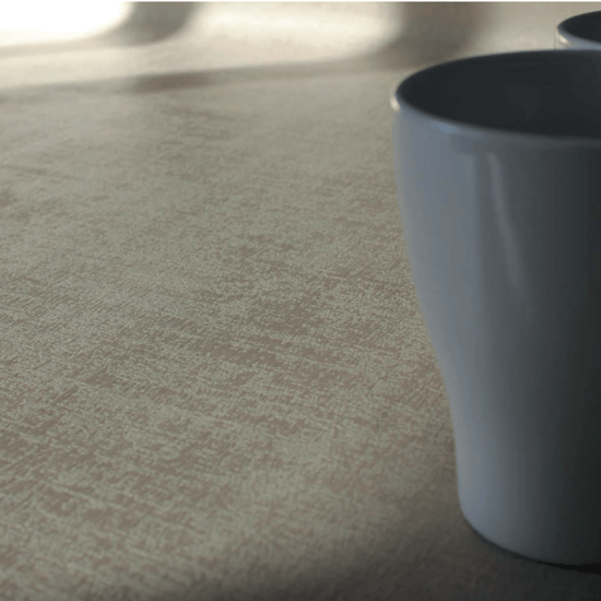 Mantel Murillo beige con taza blanca sobre superficie clara-beige
